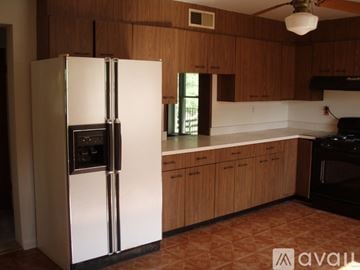 Ellicott City house for rent - A white refrigerator in a kitchen with wooden cabinets.