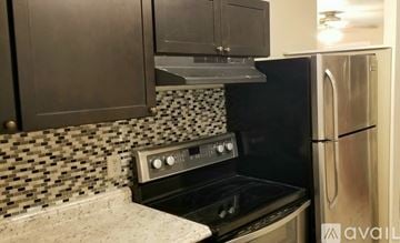 Melbourne house for rent - A kitchen with a black oven and a black and white tiled backsplash.