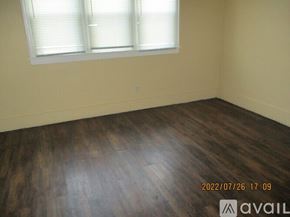 Detroit apartment for rent - A room with wooden flooring and a window with blinds.