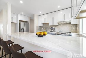 Oakland apartment for rent - A kitchen with white cabinets and a marble countertop.