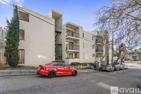 Oakland apartment for rent - A red car is parked in front of a building with a sign that reads "avail".