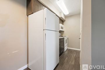 Iowa City apartment for rent - A white refrigerator in a kitchen with wooden cabinets.