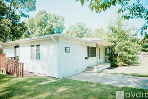 Jacksonville house for rent - A white house with a brown fence and trees in the background.