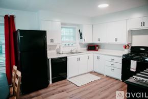 Jacksonville house for rent - A kitchen with black appliances and white cabinets.