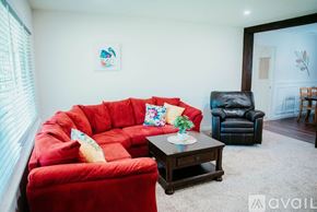 Jacksonville house for rent - A red sofa with a cushion and a small table in front of it.