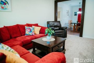 Jacksonville house for rent - A living room with a red couch and a black leather chair.