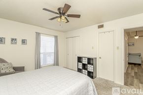 Little Rock house for rent - A bedroom with a large bed and a ceiling fan.