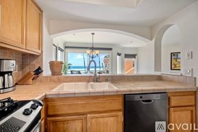 Oceanside apartment for rent - A beachfront property with a pool and palm trees.