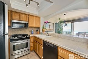 Oceanside apartment for rent - A kitchen with wooden cabinets and a black refrigerator.