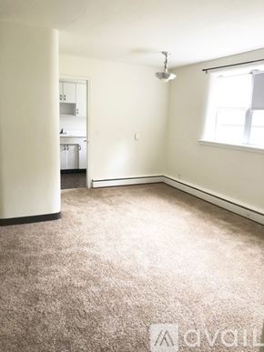 Anoka apartment for rent - A carpeted room with a window and a door leading to another room.