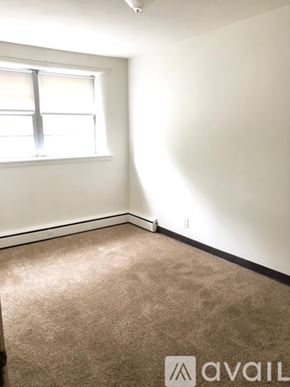 Anoka apartment for rent - A carpeted room with a window and Avail logo.