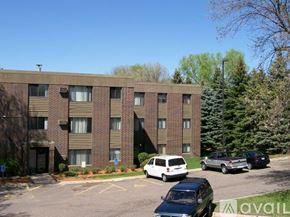 Minneapolis apartment for rent - A parking lot in front of a brick apartment building with cars parked.