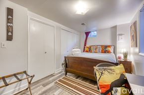 Lakewood townhouse for rent - A bedroom with a bed, a chair, and a rug.