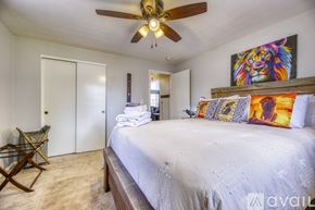 Lakewood townhouse for rent - A bedroom with a large bed and a ceiling fan.