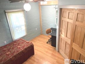Austin apartment for rent - A bedroom with a bed, a fan, and a closet.