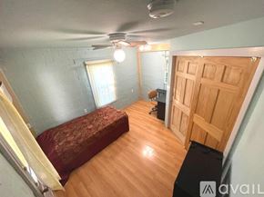 Austin apartment for rent - A room with a bed, desk, and a ceiling fan.