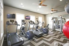 Richardson apartment for rent - A gym with treadmills, elliptical machines, and a red exercise ball.