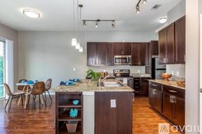 Richardson apartment for rent - A kitchen with brown cabinets and a granite countertop.