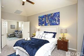 Richardson apartment for rent - A bedroom with a large bed and a blue and white painting on the wall.