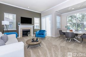 Lewisville apartment for rent - A living room with a fireplace, a white couch, a blue chair, a coffee table, and a television.