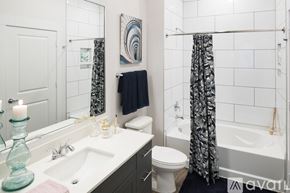Dallas apartment for rent - A bathroom with a white toilet, a white sink, a white bathtub, and a white shower curtain.