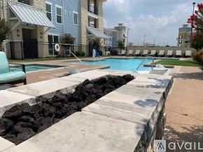 Little Elm apartment for rent - A swimming pool surrounded by a stone wall and a concrete walkway.