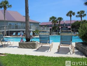 Charleston apartment for rent - A pool area with lounge chairs and a palm tree.