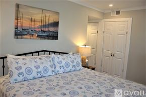 Charleston apartment for rent - A bedroom with a bed, a painting on the wall, and a lamp on the side table.