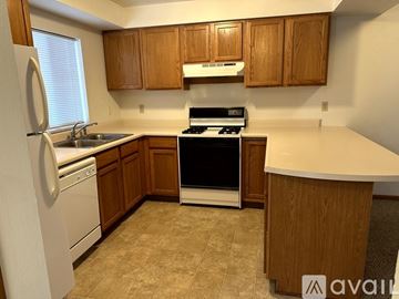 Pekin house for rent - A kitchen with wooden cabinets and a white countertop.