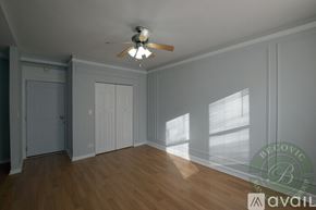 Chicago apartment for rent - A room with a ceiling fan and wooden flooring.