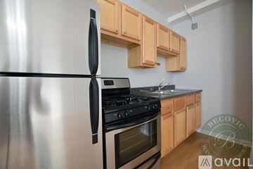 Chicago apartment for rent - A modern kitchen with a stainless steel refrigerator and wooden cabinets.