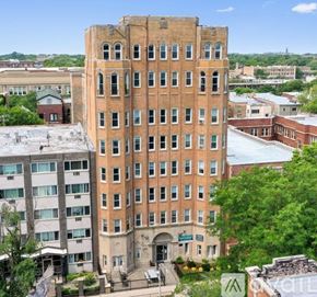 Chicago apartment for rent - A large red brick building with many windows is in the foreground.