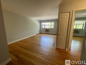 Chicago apartment for rent - A room with wooden floors and a door leading to another room.