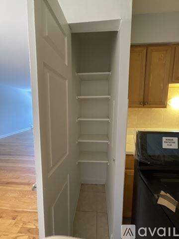 Chicago apartment for rent - A kitchen with a black fridge and wooden cabinets.