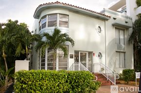 Surfside apartment for rent - A white house with a red tile roof and a sign that says "available" in front of it.