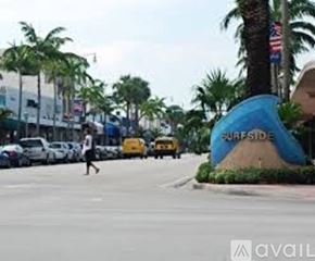 Surfside apartment for rent - A person is walking on a street with palm trees and a Surfside sign.