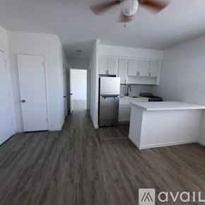 Surfside apartment for rent - A kitchen with white cabinets and a refrigerator.