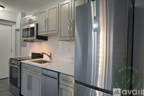 Chicago apartment for rent - A modern kitchen with stainless steel appliances and a white countertop.
