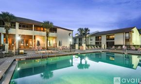 Orlando apartment for rent - A swimming pool in front of a building with a sign that says "available".