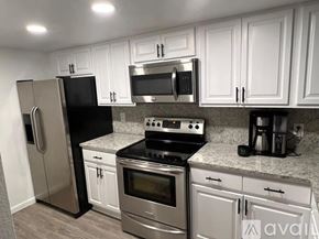 Orlando apartment for rent - A kitchen with black appliances and white cabinets.