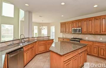 Houston house for rent - A kitchen with wooden cabinets and granite countertops.