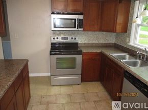 Carbondale house for rent - A kitchen with a stove, microwave, and oven.