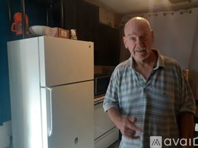 New Orleans house for rent - A man in a plaid shirt stands in front of a white refrigerator.