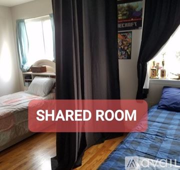 New Orleans house for rent - A bedroom with a bed and a poster on the wall.