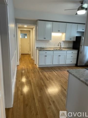 Worcester apartment for rent - A kitchen with white cabinets and a wooden floor.
