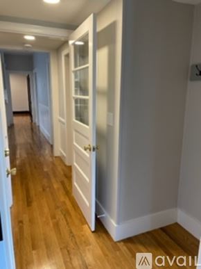 Worcester apartment for rent - A hallway with wood floors and white walls.