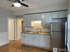 Worcester apartment for rent - A kitchen with white cabinets and a stainless steel refrigerator.