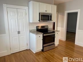 Worcester apartment for rent - A kitchen with white cabinets and a black stove top oven.