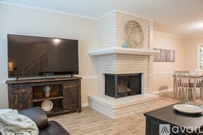 Shreveport townhouse for rent - A living room with a fireplace and a television.