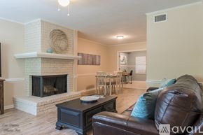 Shreveport townhouse for rent - A living room with a fireplace and a couch.